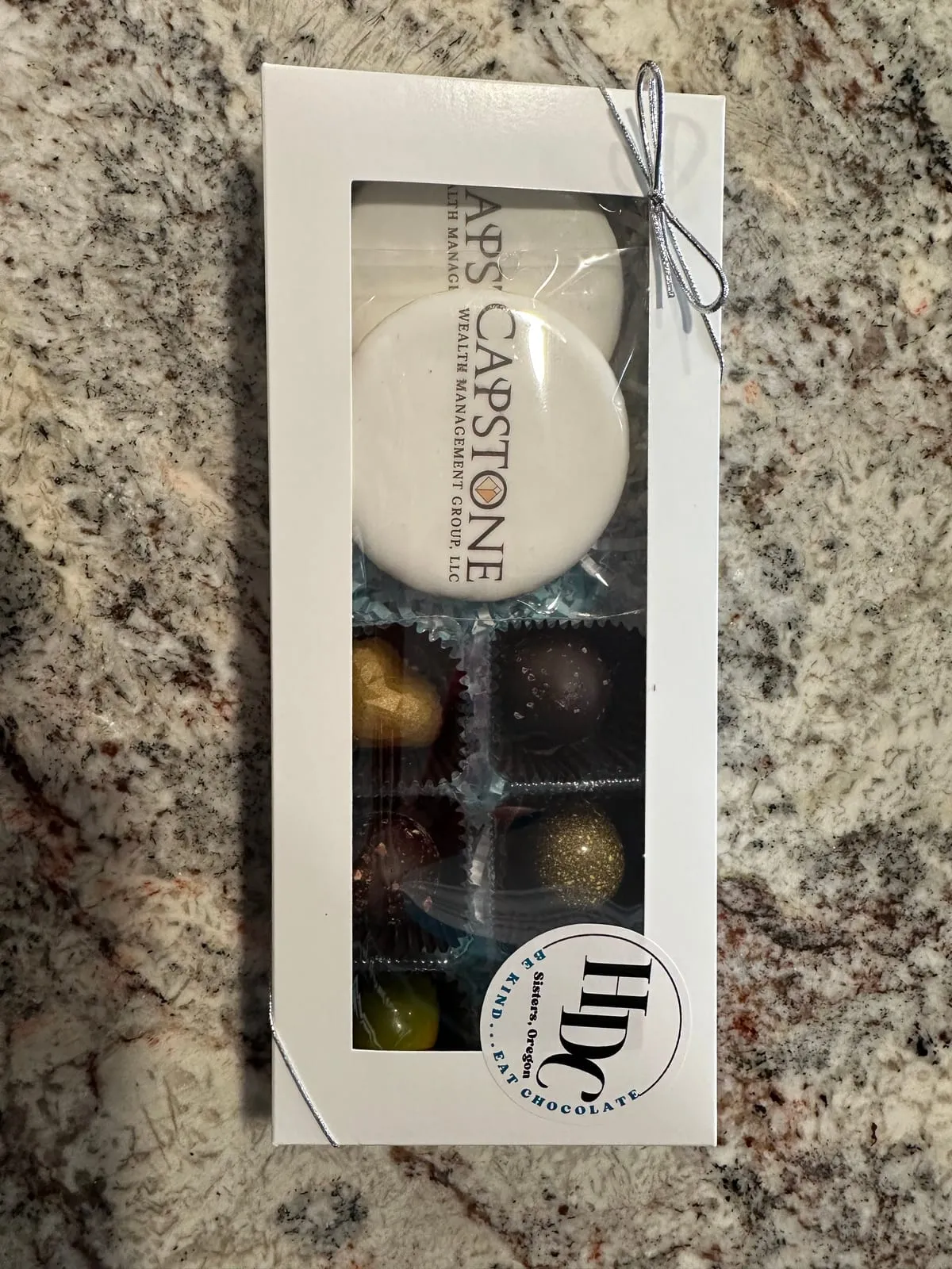A clear gift box of logo truffles for a corporate event